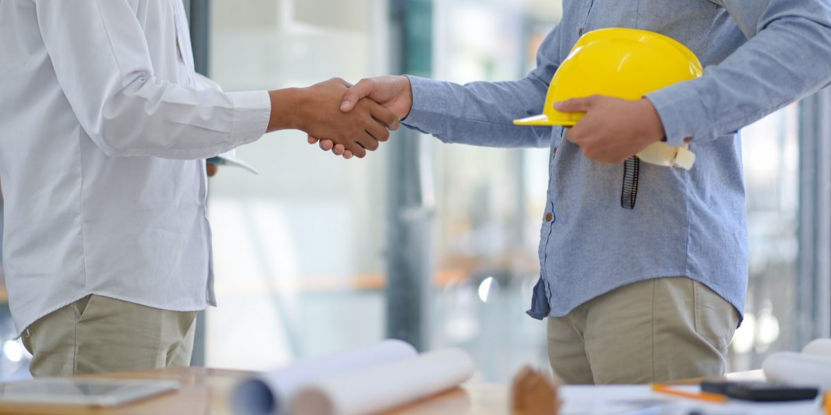 Architects and contractors shake hands to work.