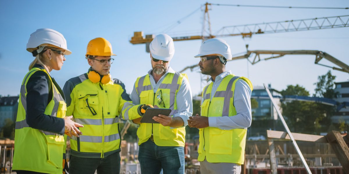 Diverse,Team,Of,Specialists,Use,Tablet,Computer,On,Construction,Site.